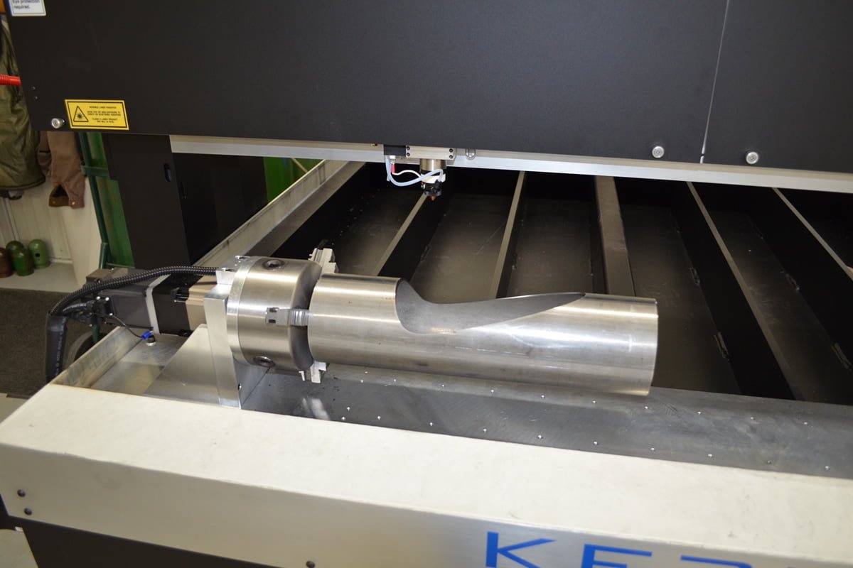 Metal pipe being laser cut with Chuck Rotary attachment
